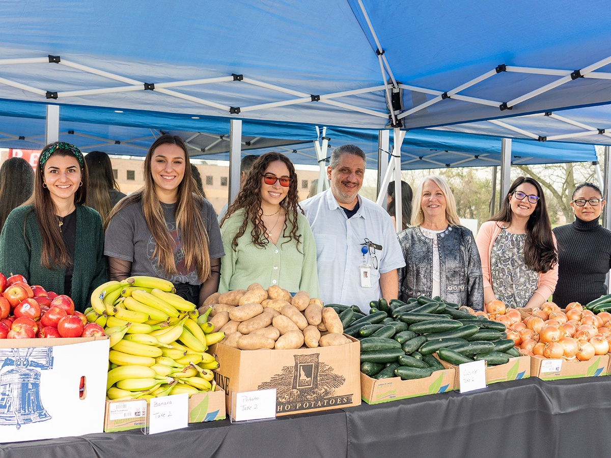 pictured are Tweezerman employees standing at fresh produce table for event
